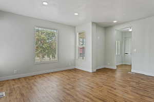 Unfurnished room with recessed lighting, baseboards, visible vents, and light wood-type flooring
