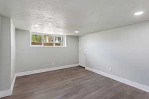 Spare room with baseboards, a textured ceiling, recessed lighting, and wood finished floors