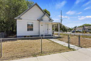 Bungalow with a porch, a fenced front yard, a gate, and a front yard