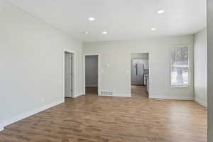 Unfurnished living room featuring baseboards, recessed lighting, wood finished floors, and visible vents
