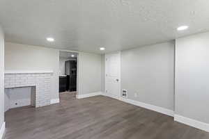 Unfurnished living room featuring a textured ceiling, recessed lighting, baseboards, wood finished floors, and visible vents