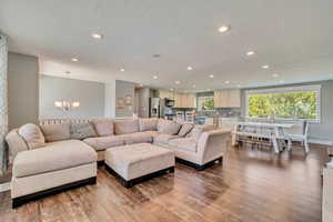 Living room featuring a notable chandelier, recessed lighting, and wood finished floors