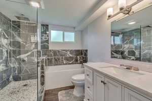 Full bath with a garden tub, toilet, wood finished floors, a stall shower, and vanity