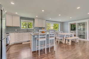 Kitchen with dark wood-style floors, a healthy amount of sunlight, and appliances with stainless steel finishes