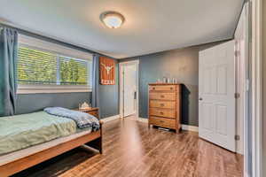 Bedroom with baseboards and wood finished floors