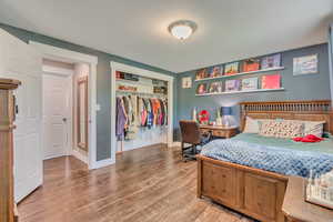 Bedroom featuring a closet, baseboards, and wood finished floors