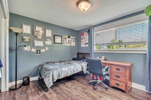 Bedroom with wood finished floors and baseboards