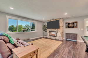 Living room featuring a multi sided fireplace, visible vents, recessed lighting, and wood finished floors