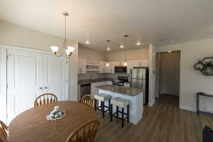 Dining room featuring dark wood-style flooring, baseboards, visible vents, and recessed lighting