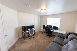 Office space featuring baseboards, carpet flooring, and a textured ceiling