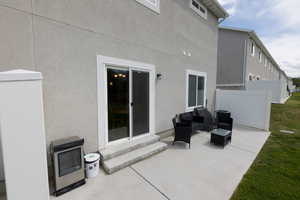 View of patio featuring entry steps, outdoor lounge area, heating unit, and fence