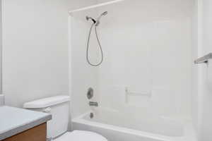 Bathroom featuring vanity, toilet, and tub / shower combination
