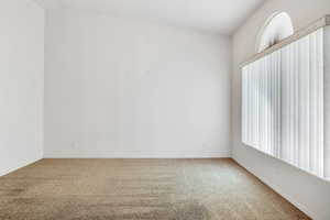 Empty room featuring baseboards and carpet