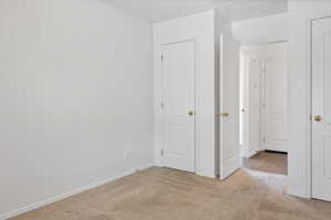 Unfurnished bedroom featuring carpet and baseboards
