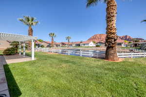 View of yard featuring a pergola, fence, a mountain view, and a residential view