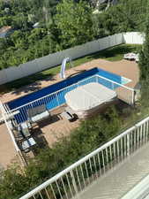 View of pool featuring a fenced in pool, a water slide, and a fenced backyard