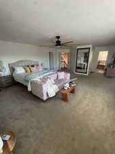 Bedroom with carpet, a textured ceiling, and ceiling fan