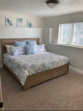 Carpeted bedroom featuring a textured ceiling and baseboards
