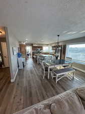 Dining room with recessed lighting, a textured ceiling, baseboards, and hardwood / wood-style flooring