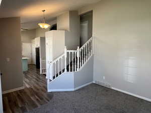 Stairway with baseboards, visible vents, carpet, and wood finished floors