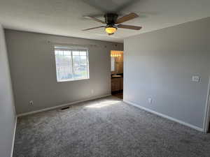 Unfurnished room with baseboards, carpet floors, a ceiling fan, and visible vents