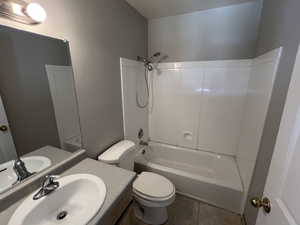 Bathroom featuring toilet, tile patterned floors, vanity, and shower / bathing tub combination