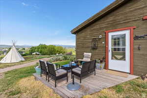 Wooden deck with outdoor lounge area, a mountain view, and a lawn