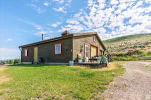 View of property exterior featuring a yard and a deck