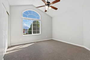 Living room just off the entry featuring visible vents, baseboards, carpet flooring, and vaulted ceiling