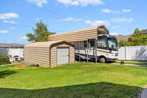 View of storage shed/shop, covered RV parking, both with 110/220v electrical hookups.
