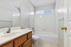 Full bath with vanity, tile patterned flooring, toilet, and shower / tub combination.