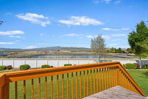 Elevated deck with a concrete patio below and fenced backyard.