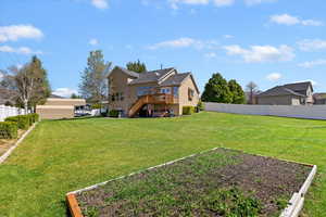 View of yard with stairs, fence, a vegetable garden, and a deck