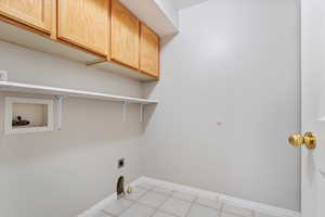 Clothes washing area with cabinet space, hookup for a washing machine, hookup for a gas dryer, baseboards, and electric and gas dryer hookup