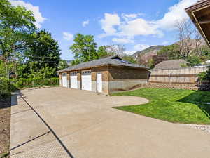 View of side of property with brick siding, a garage, and a mountain view