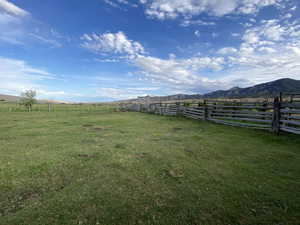 View of yard featuring fence, a rural view, and a mountain view