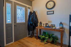 Foyer entrance with wood finished floors and baseboards
