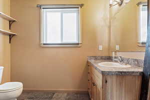 Bathroom with toilet, baseboards, and plenty of natural light