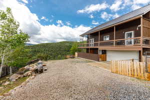 View of home's exterior featuring gravel driveway, a garage, a mountain view, and metal roof