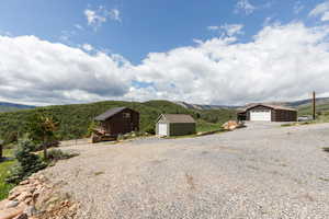 View of outbuilding with a mountain view and gravel driveway