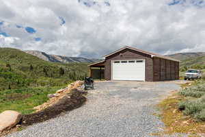 Garage with a mountain view and gravel driveway