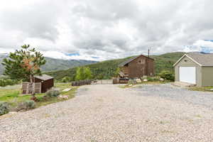 View of yard featuring a mountain view, an outbuilding, and a garage