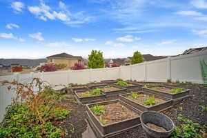 View of yard with a fence, and raised garden boxes