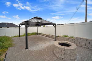 View of patio with a gazebo, a fire pit, and a fenced backyard