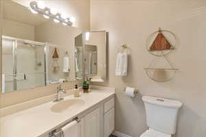 Full bathroom with a stall shower, vanity, and toilet