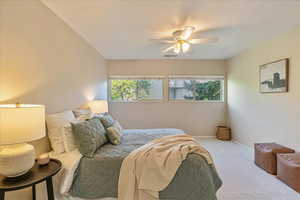 Carpeted bedroom featuring baseboards, ceiling fan, and visible vents