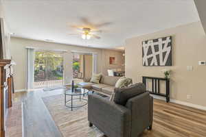 Living area featuring baseboards, a ceiling fan, and wood finished floors