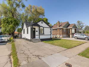 Bungalow-style home featuring a front yard, stucco siding, and driveway