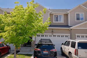 Townhome / multi-family property with driveway, stucco siding, and an attached garage
