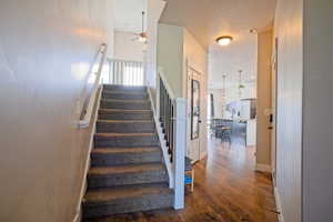 Stairs featuring baseboards, a ceiling fan, and wood finished floors